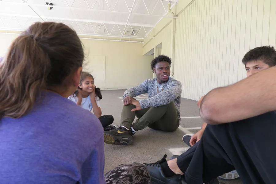 A YBYG team member speaking with program participants