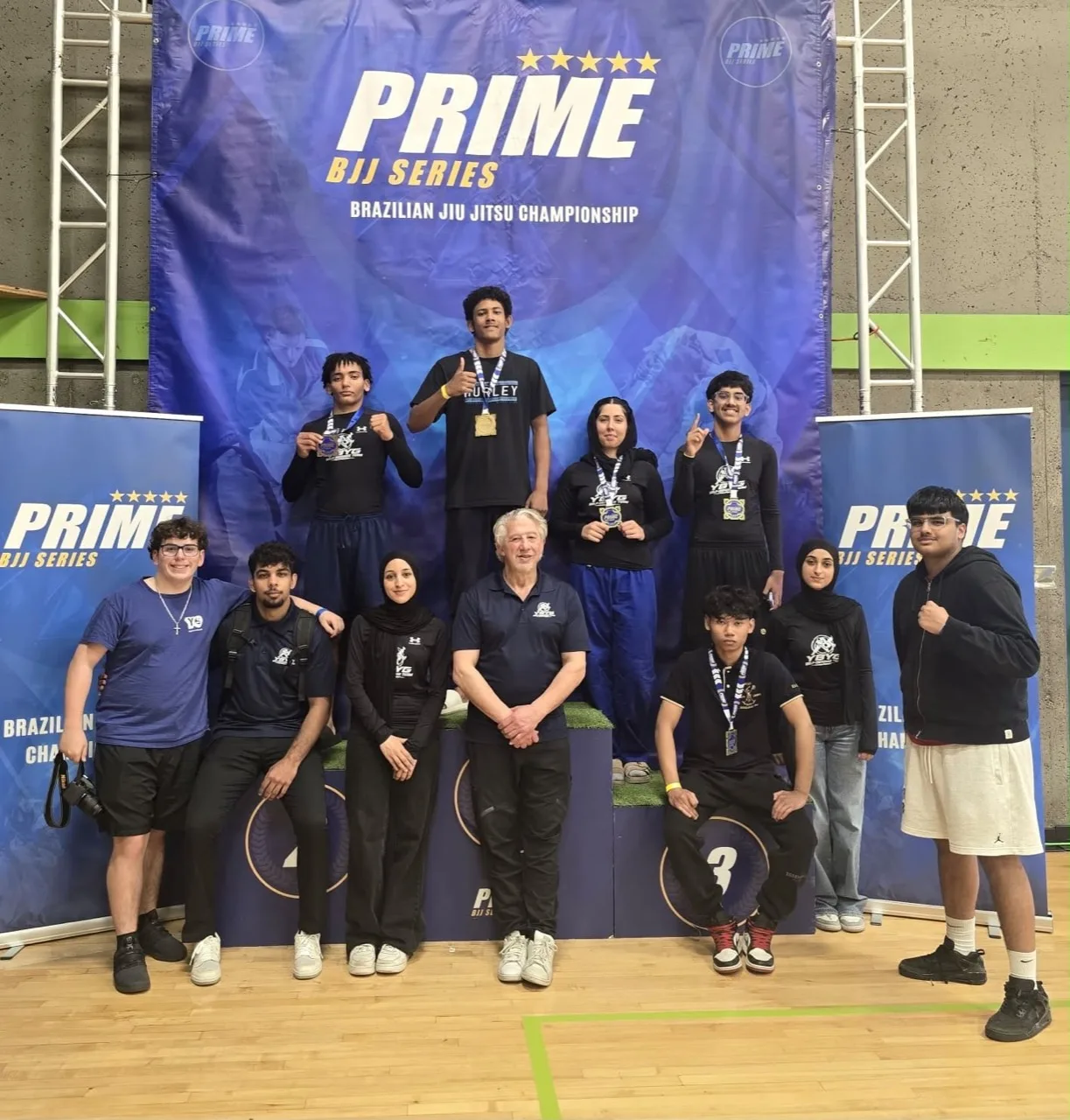 YBYG group in front of the Prime Brazilian Jiu-Jitsu championship backdrop
