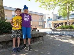 Two students standing together in a schoolyard