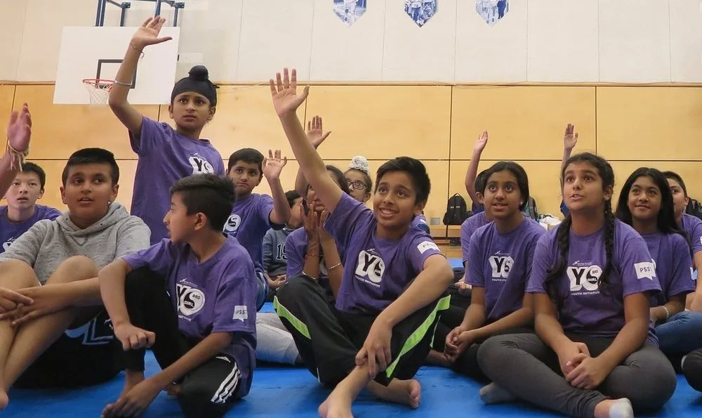 Children in purple shirts taking part in a YBYG group activity